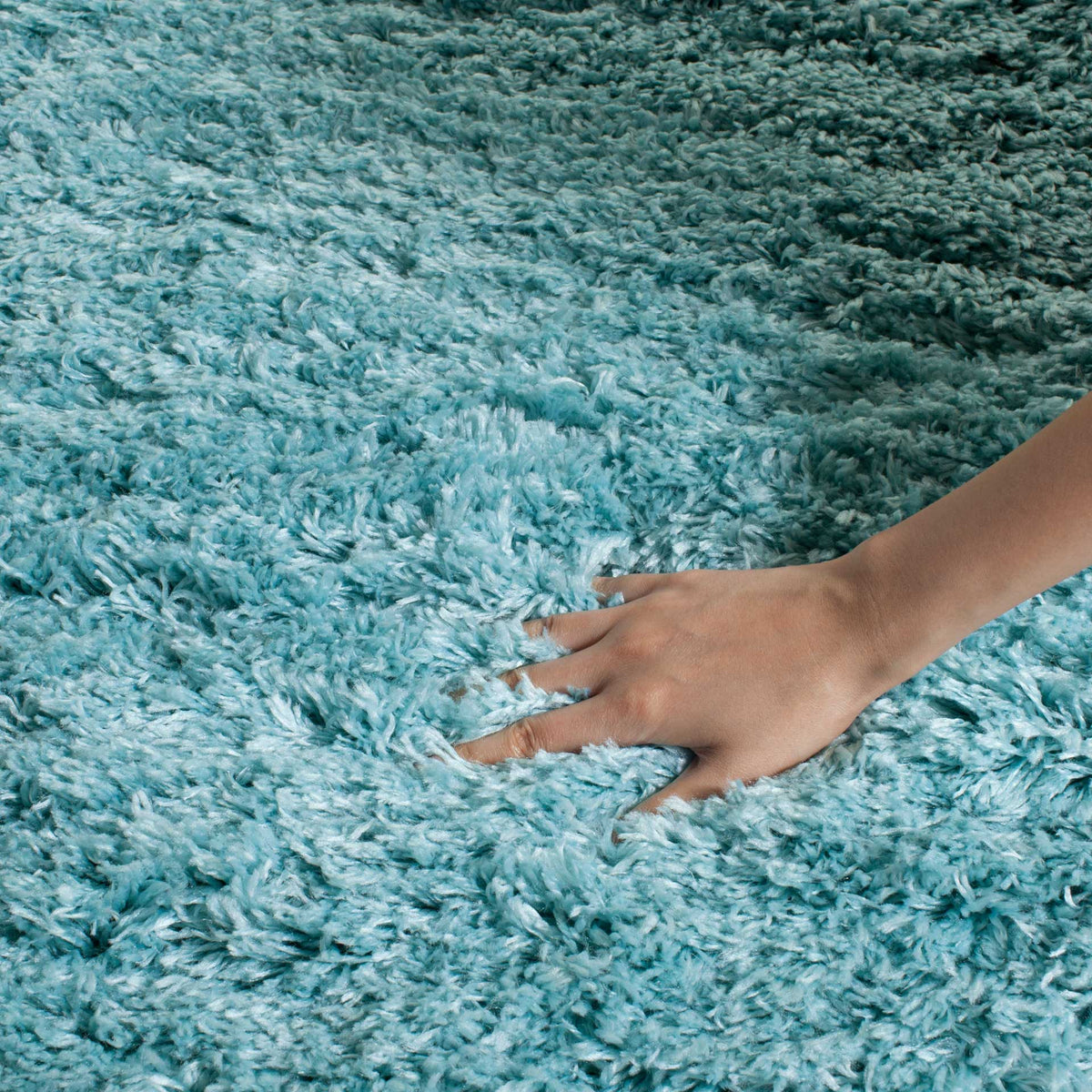 Long turquoise shag fibers create a dense, cushiony surface that welcomes every touch.