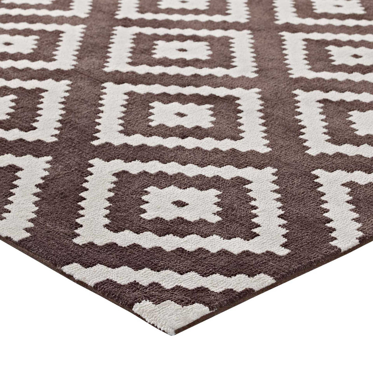 Soft brown and ivory diamond motifs meet at a neatly finished rug edge.