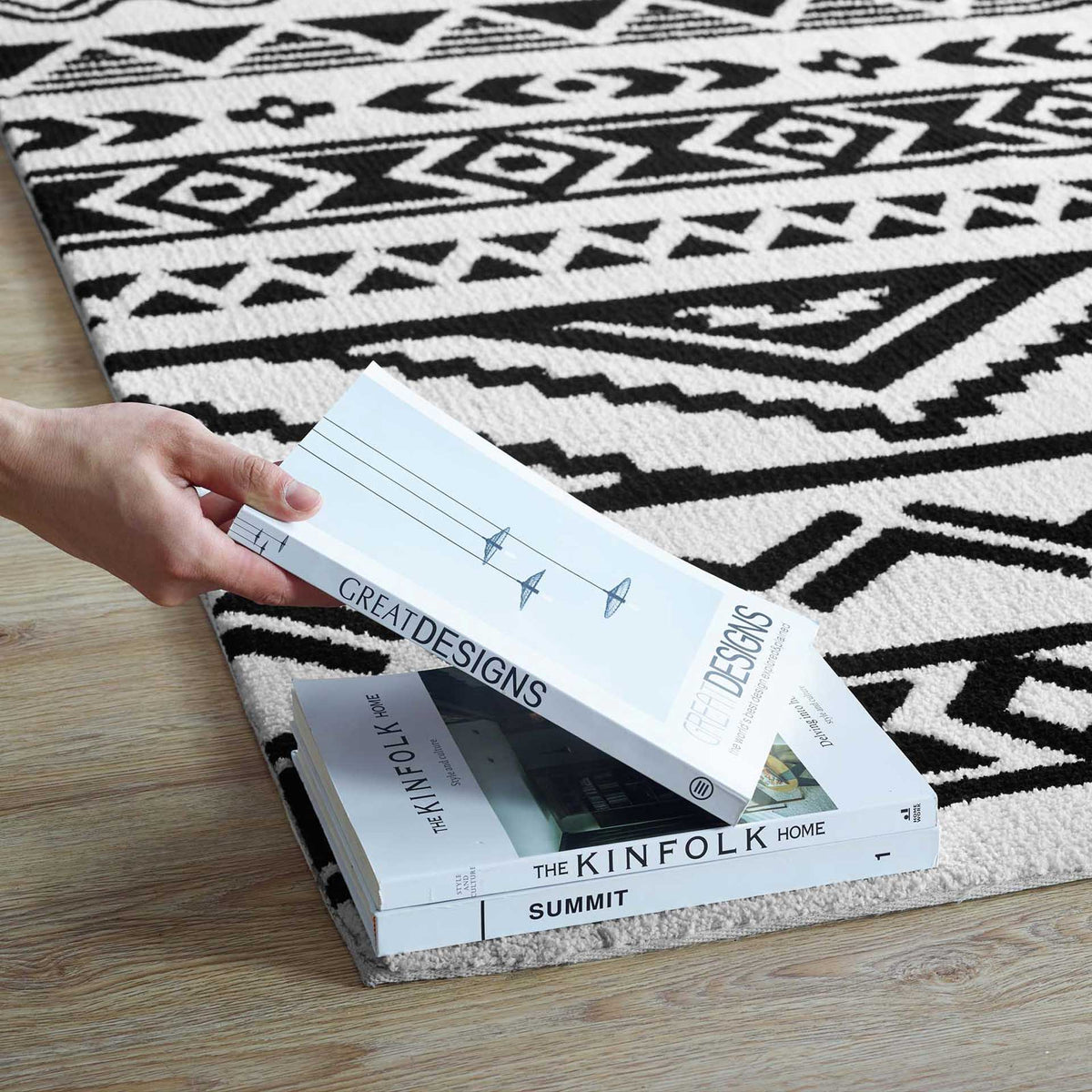 A finished edge and dense black-and-white pattern create a cozy spot for a stack of books.