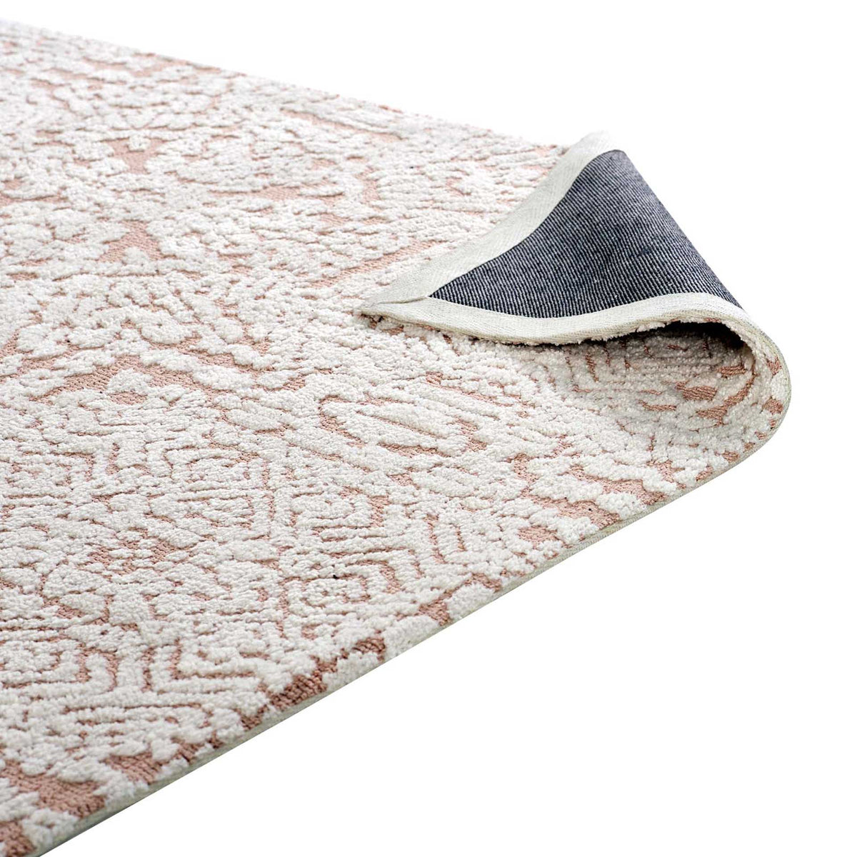 A folded rug edge reveals woven backing beneath the ivory and rose pile