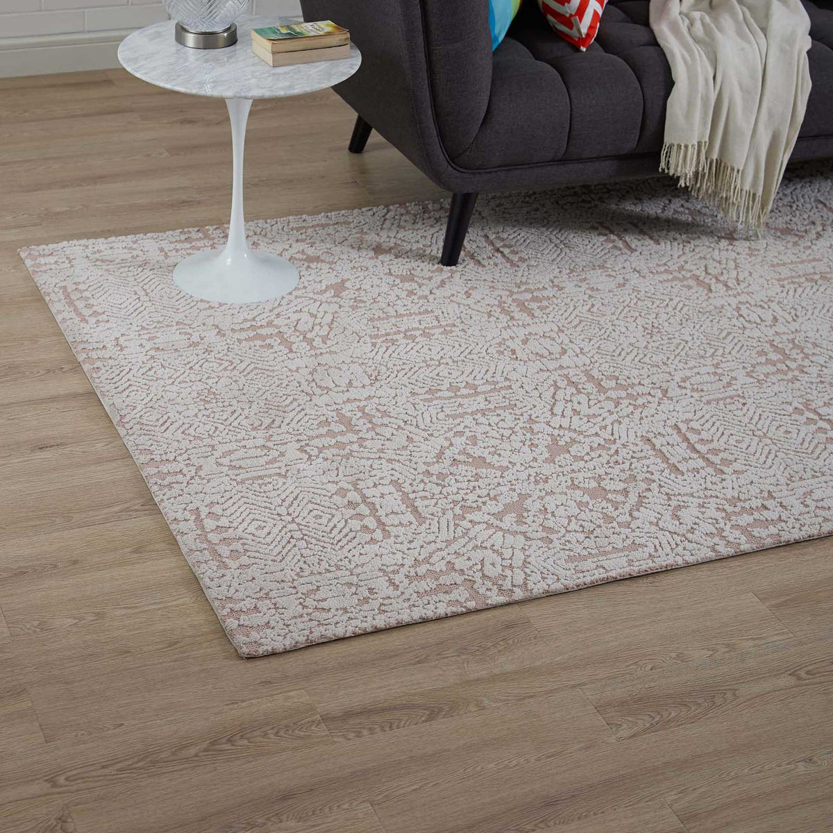 An ivory and rose geometric rug adds subtle color and softness to a living room