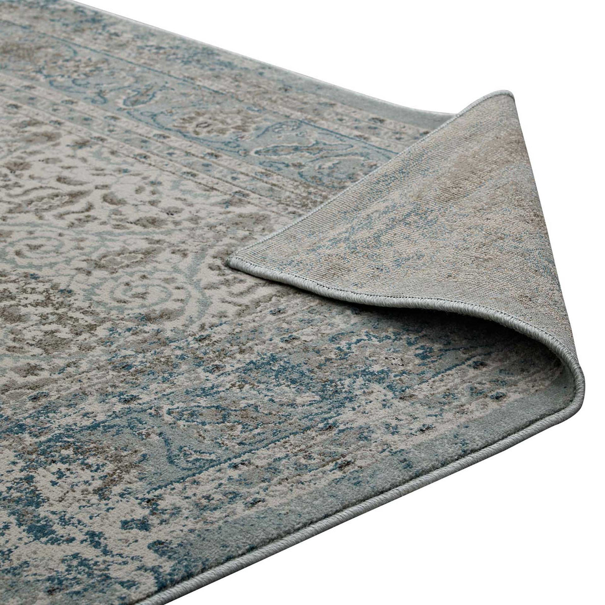 Woven backing and finished edges complement the faded floral surface of this area rug.