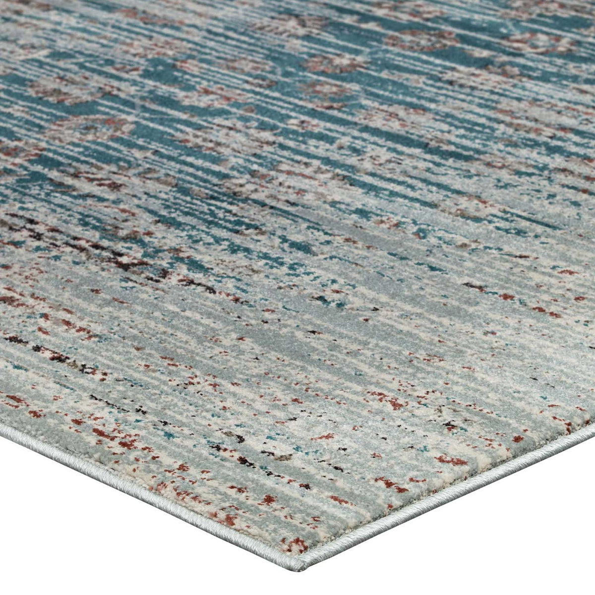 A slim bound corner frames a tight, low-pile weave with teal, beige, and brown distressing
