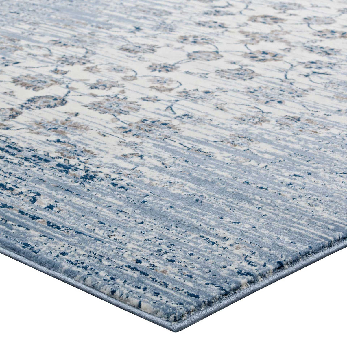 Neatly finished edges frame low blue pile with faint floral accents and ivory detailing.