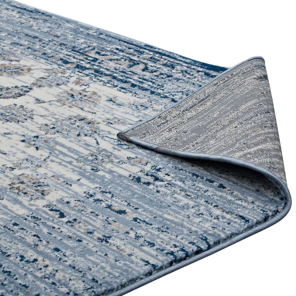 A textured backing and bound edge complete the rug's faded blue and ivory floral design.