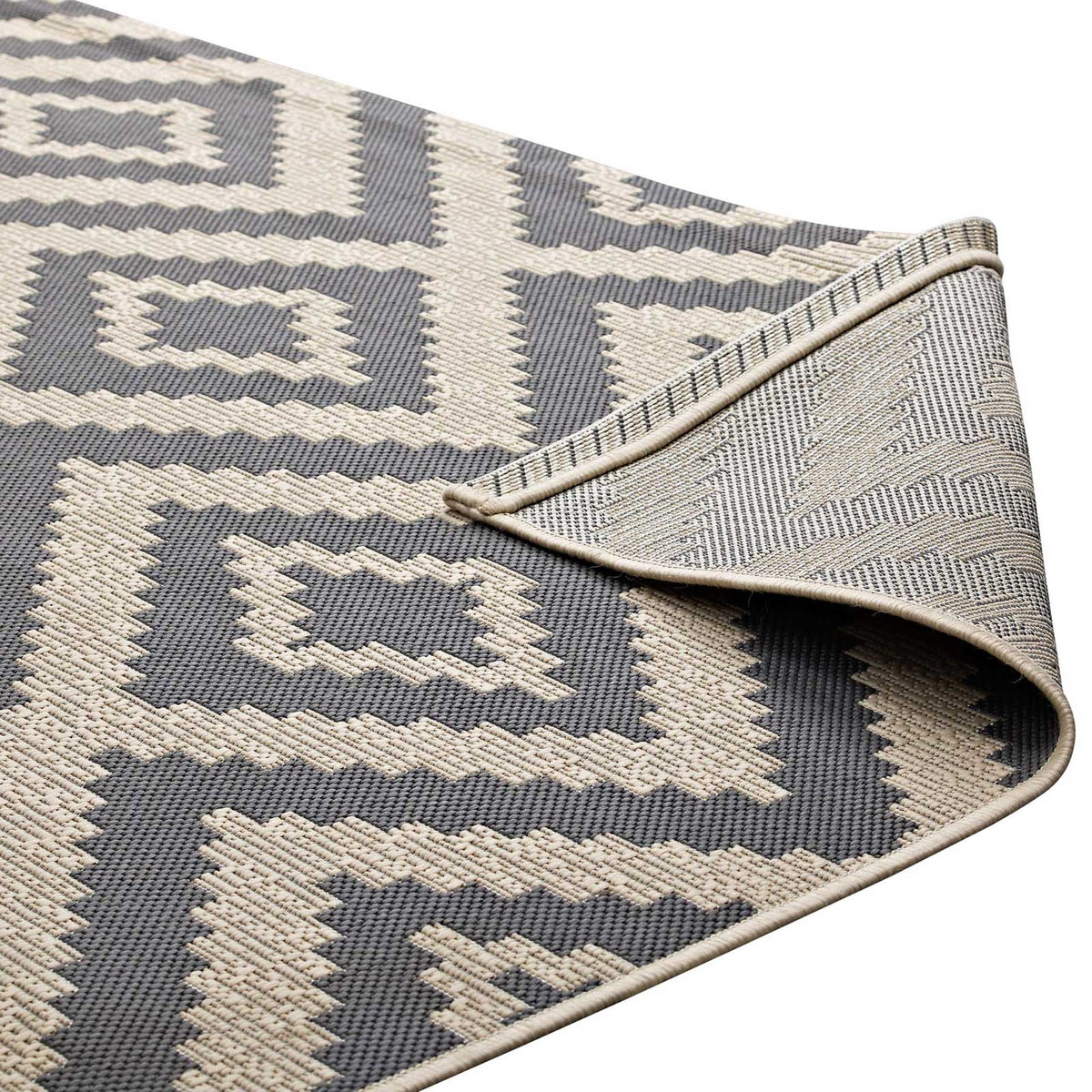 The rug's woven underside and finished edge complement its graphic diamond pattern