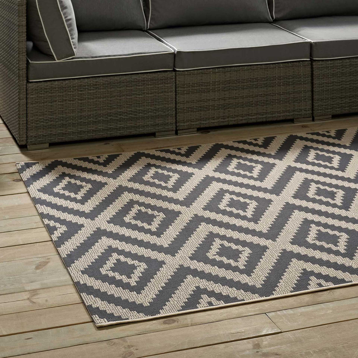 Gray and beige diamond motifs add graphic texture beneath cushioned outdoor seating