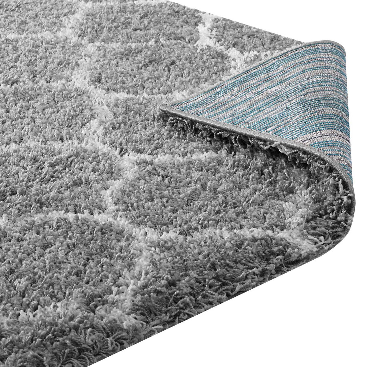 A woven backing and bound edge support the plush gray and ivory shag