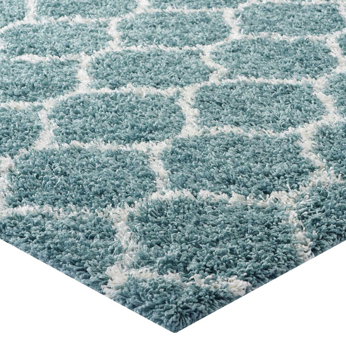 Fluffy aqua pile meets ivory lattice lines along a softly finished rug edge