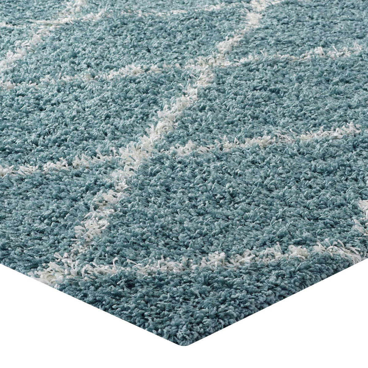 Plush aqua blue pile and ivory lattice lines meet at a neatly finished rug corner.