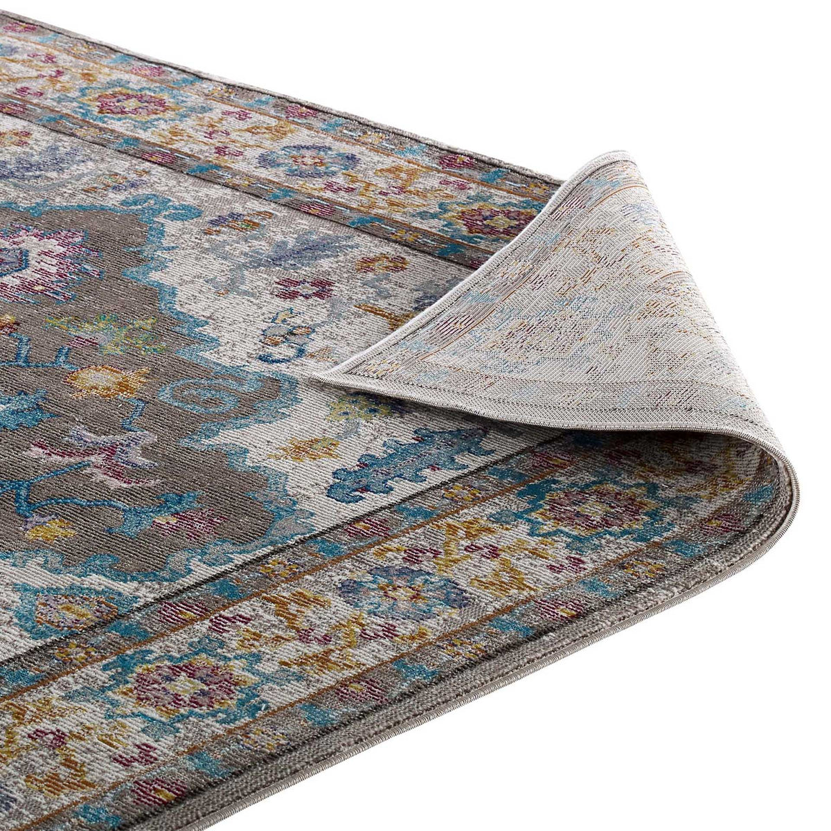 A pliable edge reveals the tightly woven underside beneath a muted floral design