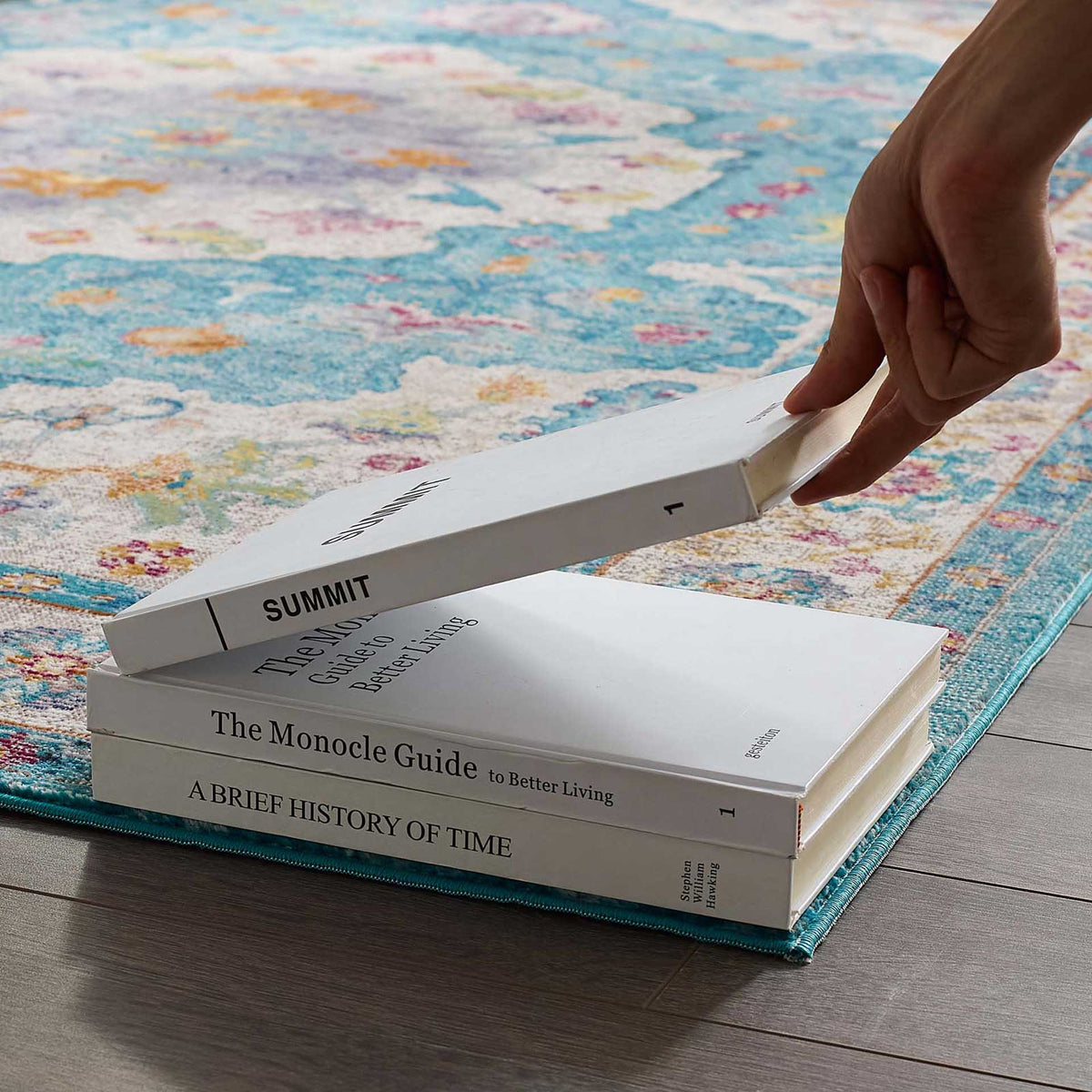 A smooth, low-profile floral weave sits neatly beneath a stack of books