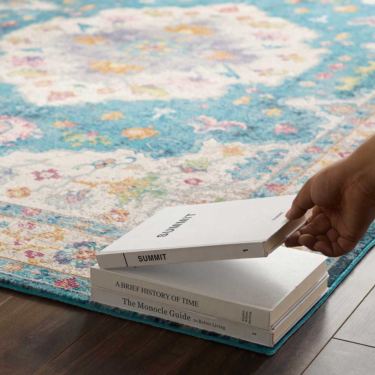 The low-pile blue floral rug offers a smooth surface for books and everyday living