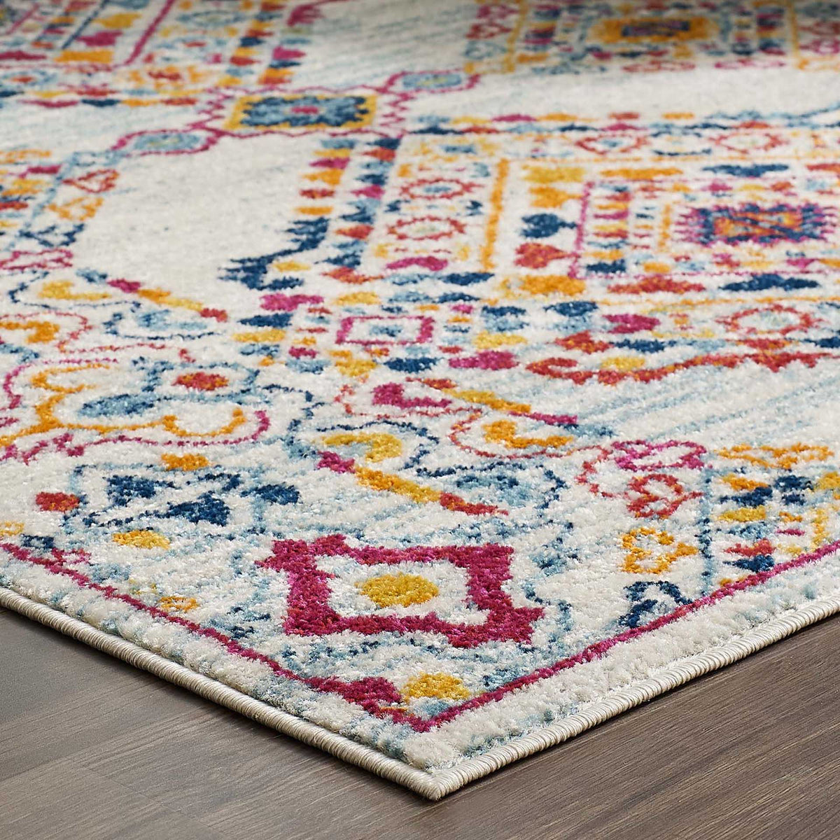 A tidy ivory border finishes the bright geometric pattern against a wood floor.