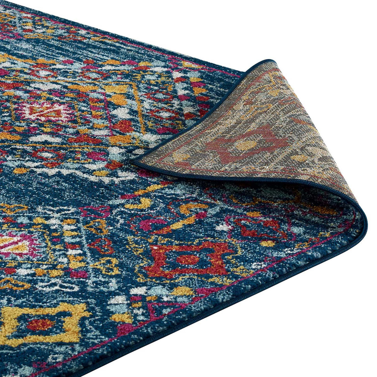 A folded edge reveals a textured underside beneath richly colored diamond motifs.