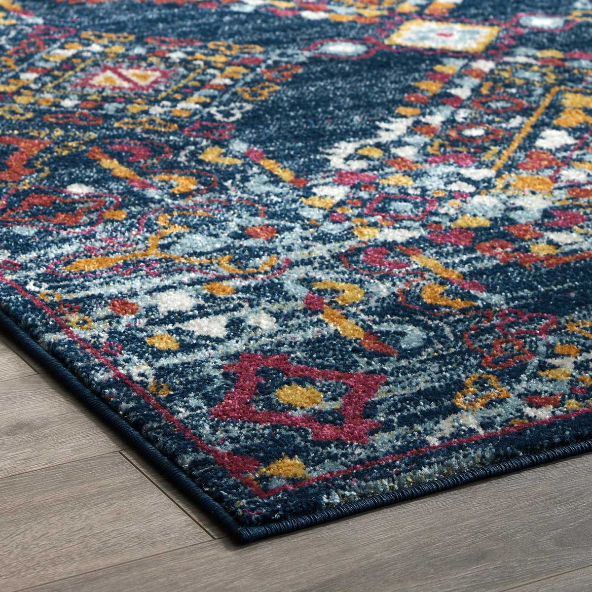 Neat navy binding outlines the rug's low-profile corner and vivid geometric accents.