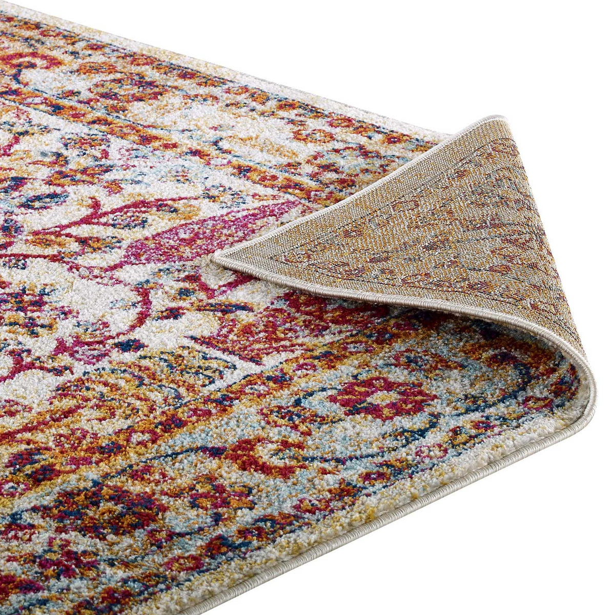 A folded ivory-bound edge reveals the textured underside beneath a colorful floral weave.