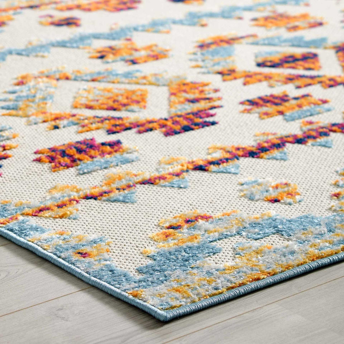 Raised blue and golden accents add dimension to the rug's tailored edge