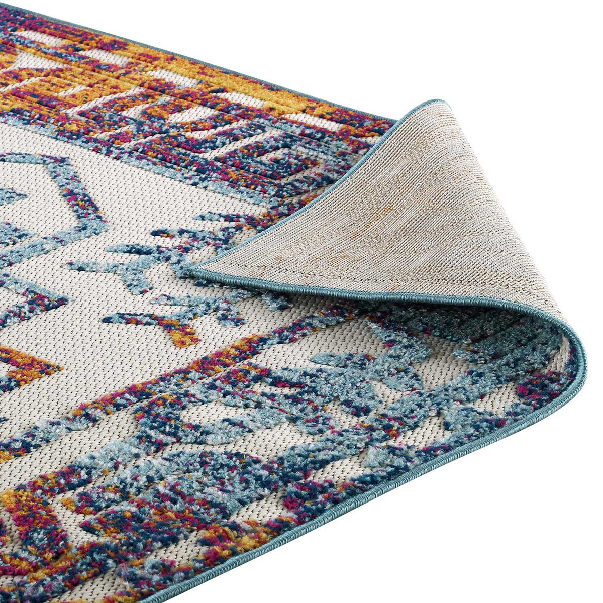 The rug's bound blue edge meets a light woven underside beneath its colorful border