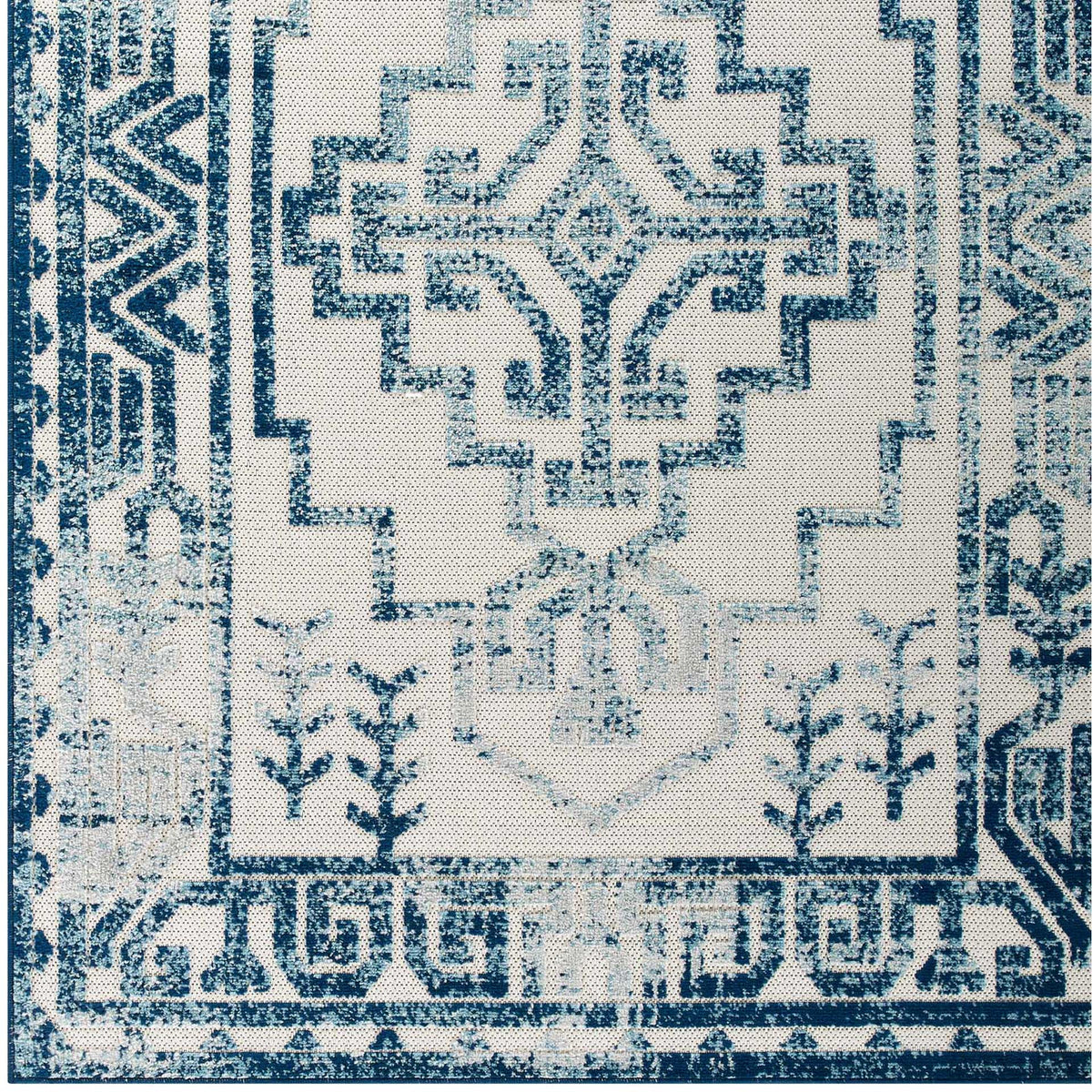 A central stepped medallion pairs with delicate blue sprigs and a patterned border