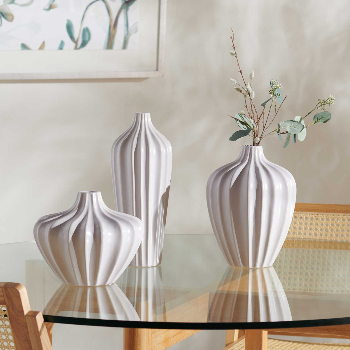 Three sculptural vases bring fluted texture to a tabletop, with one holding delicate leafy stems