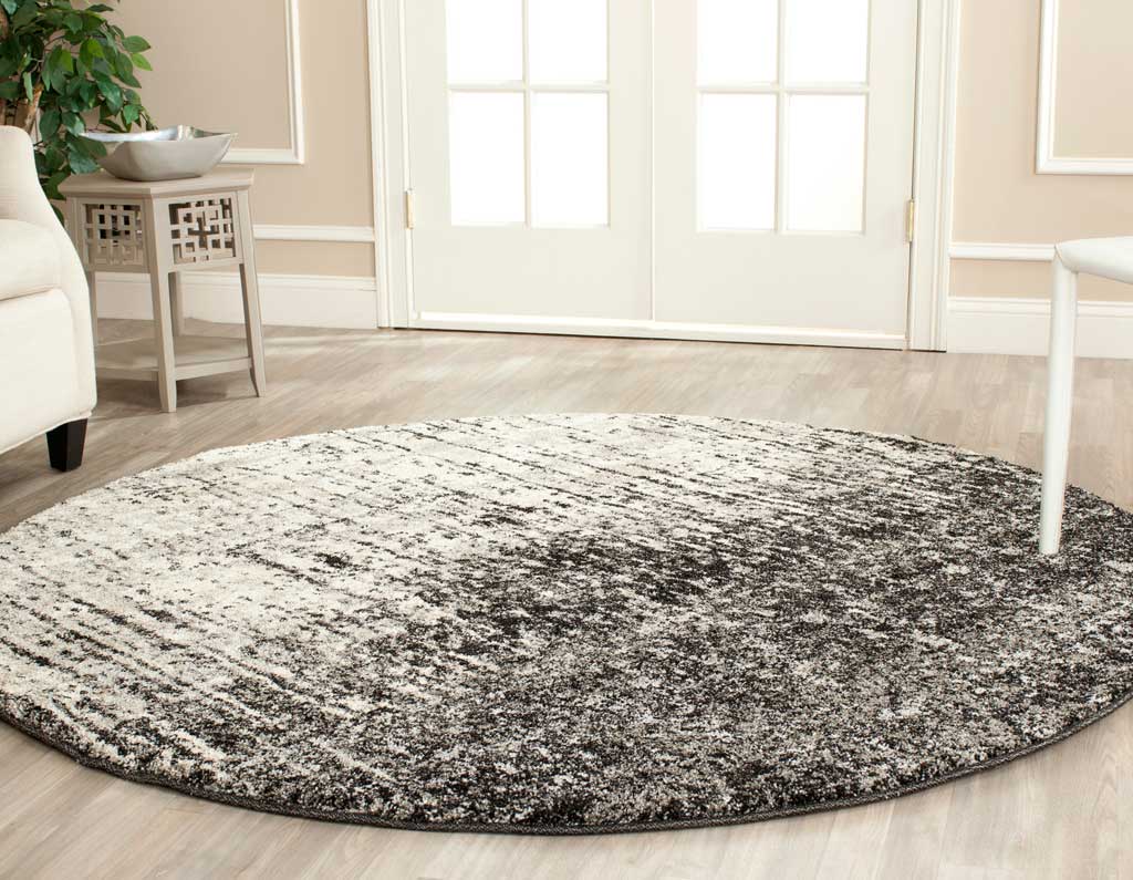 Plush round rug brings softly blended black and light gray texture to a bright living space