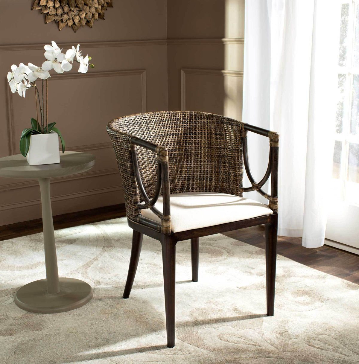 Warm rattan weave, sculptural arms, and a white cushioned seat contrast with dark wood.