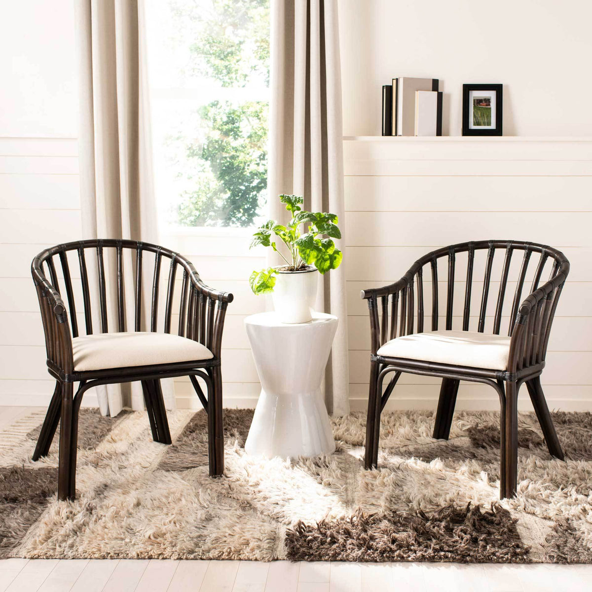 Matching curved armchairs with white seats bring inviting comfort to a bright seating area.