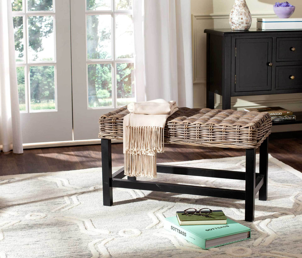 A thick woven seat and open black base give this gray bench an airy, versatile look