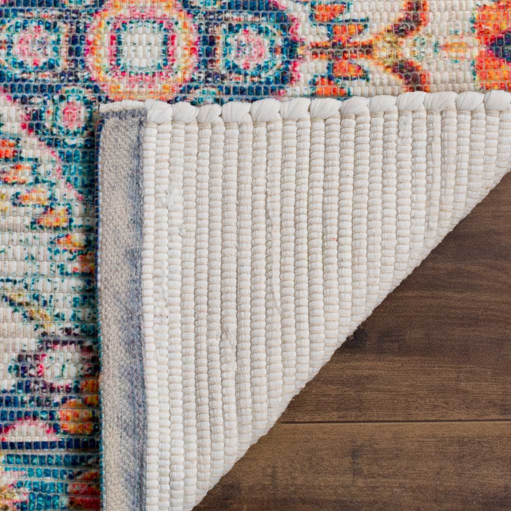 A folded rug corner reveals ribbed ivory backing beneath its colorful patterned surface