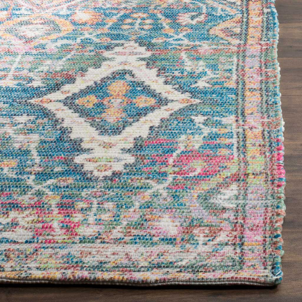 Textured turquoise and peach fibers meet at the rug's neatly finished patterned edge