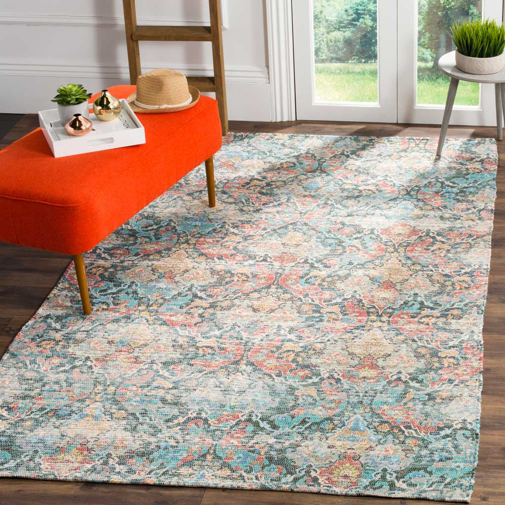 A coral and aqua rug brings ornate, vintage-inspired style to a bright living space.
