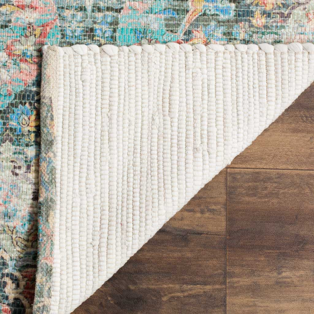 An ivory ribbed backing lies beneath the rug's colorful coral and aqua surface.