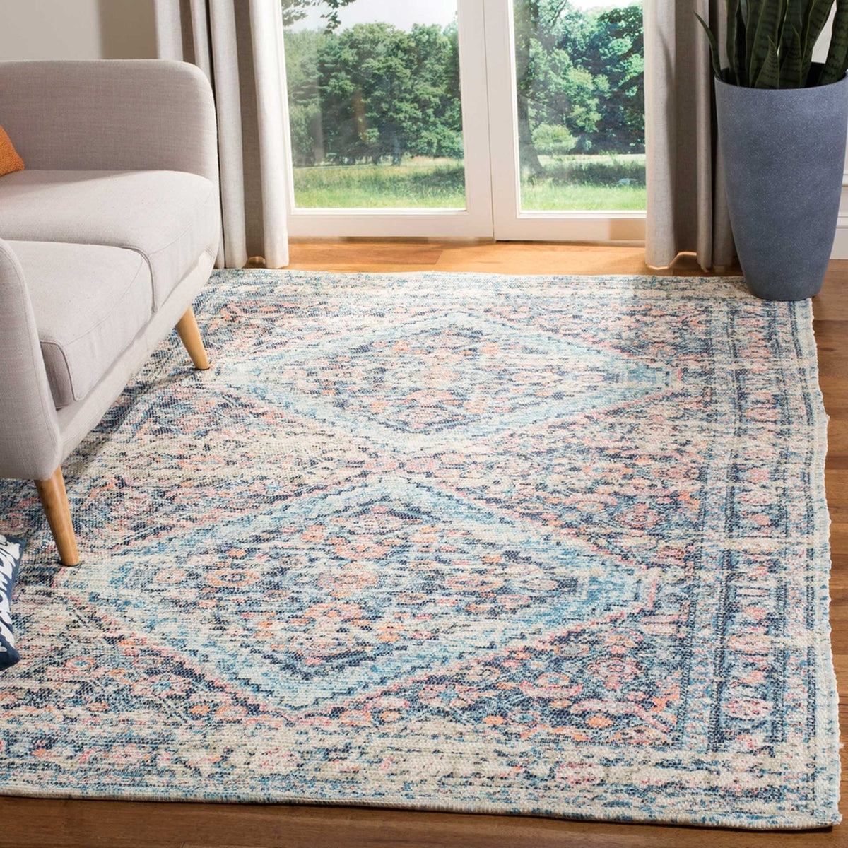 A blue and turquoise medallion rug brings soft color and vintage charm to a bright living room