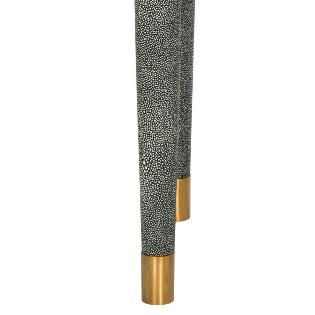 Tapered, textured legs end in warm brass caps
