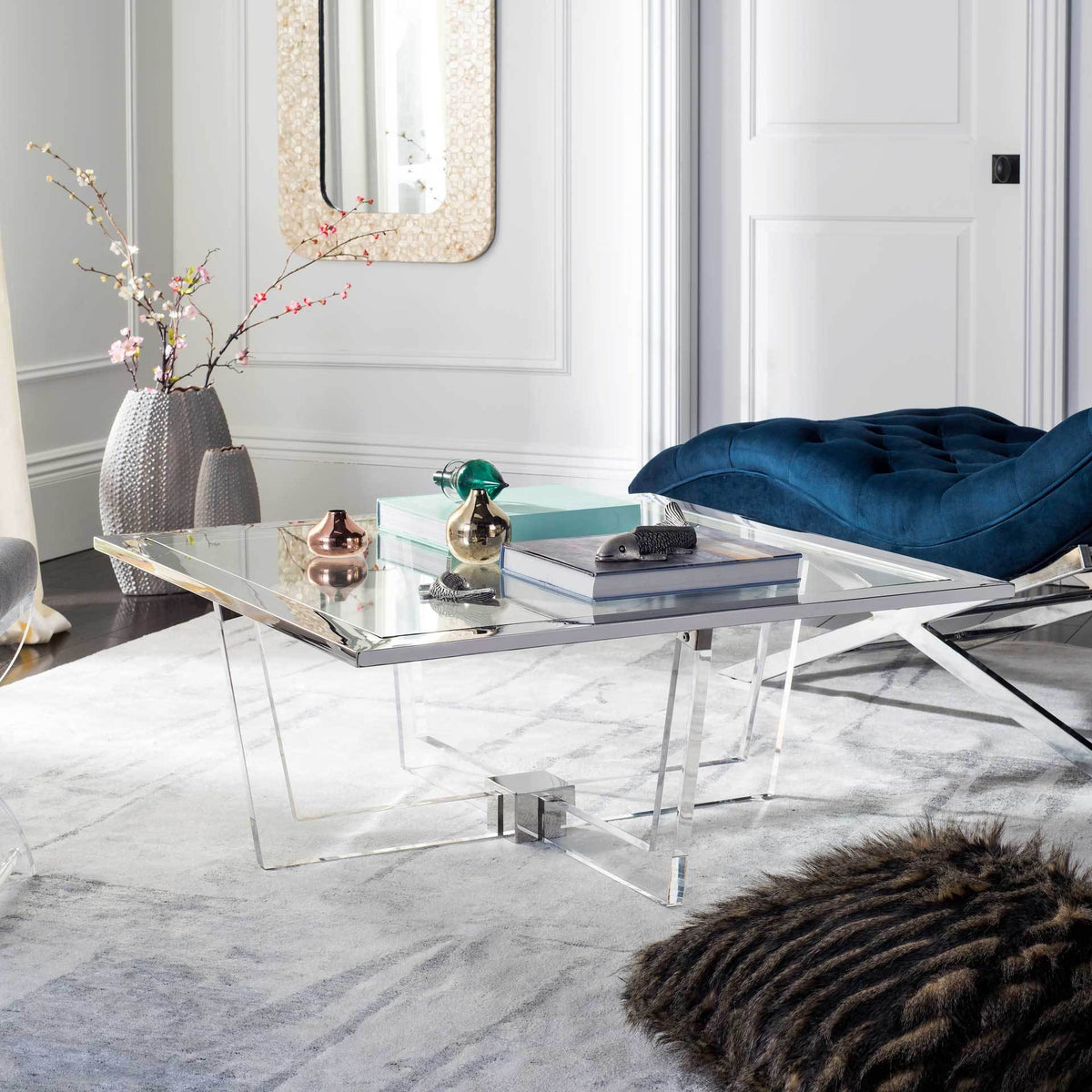Metal-trimmed clear coffee table with sculptural acrylic legs adds an airy feel to the living room