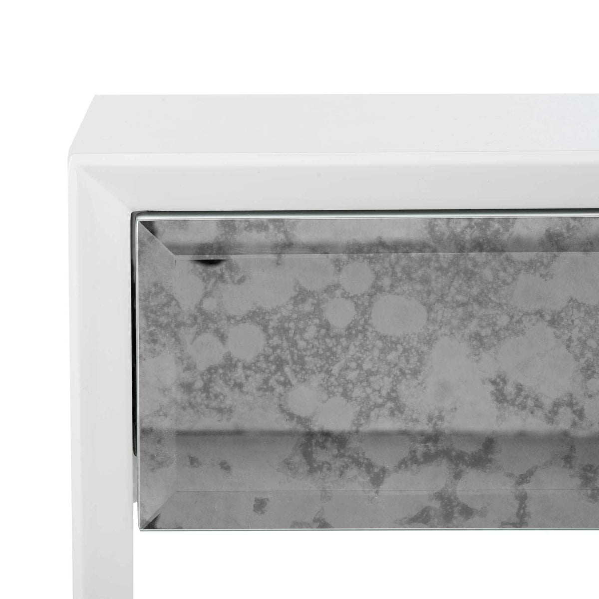 A beveled antiqued mirror drawer front brings mottled silver texture to the smooth white frame.