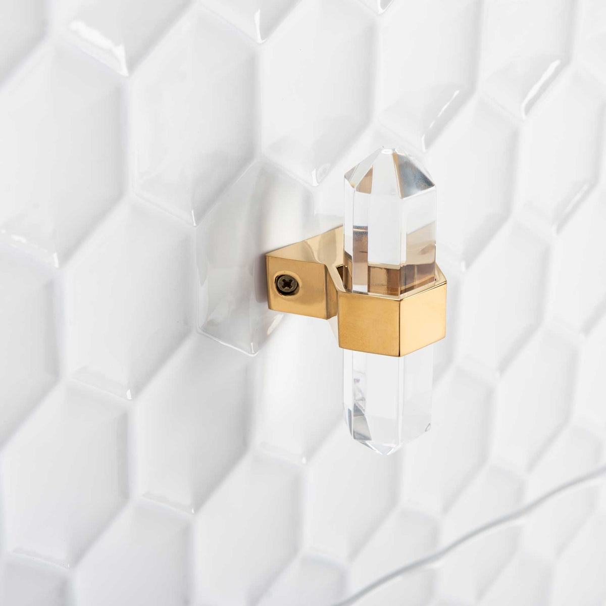 A clear faceted pull and polished gold-tone bracket add a jewel-like accent to the white textured drawer.