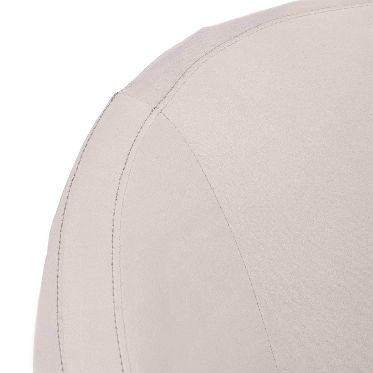 Fine stitching outlines the curved edge of the pale taupe velvet upholstery