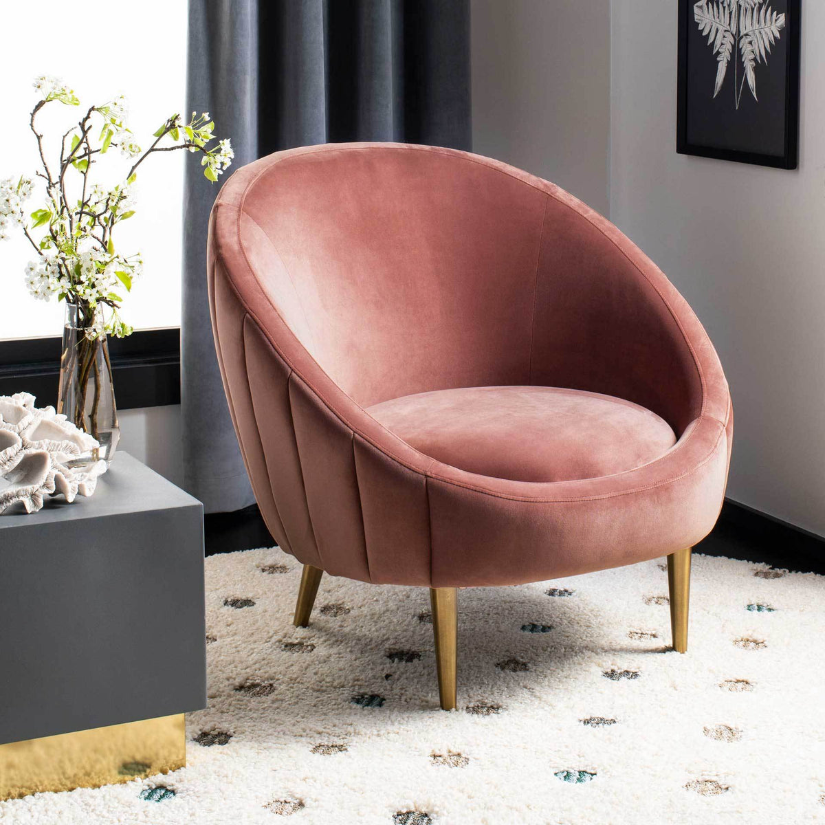 The rounded dusty rose velvet chair adds soft color and gold accents to a cozy corner