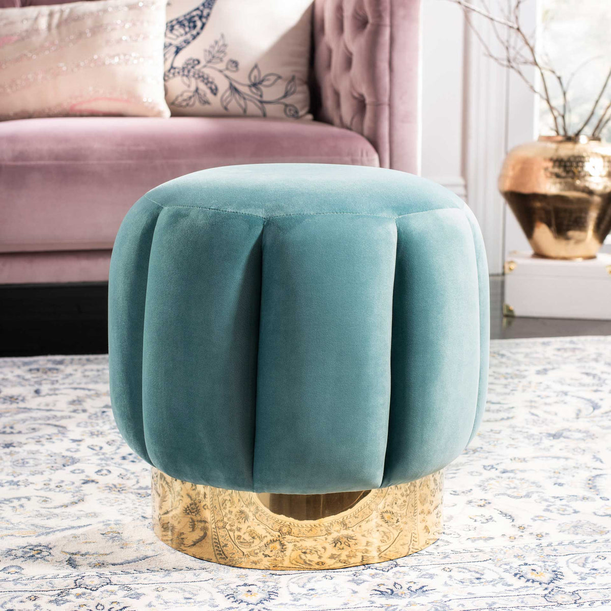 A seafoam velvet ottoman adds a soft splash of color beside the sofa.