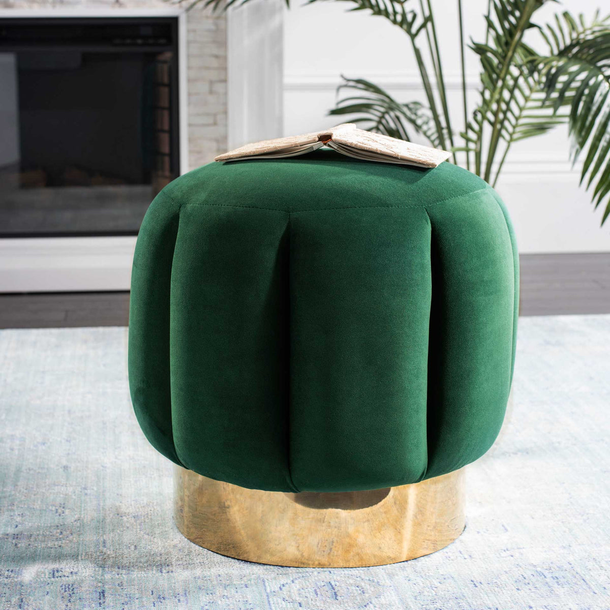 An emerald velvet ottoman lends jewel-toned color and plush texture to the living room.