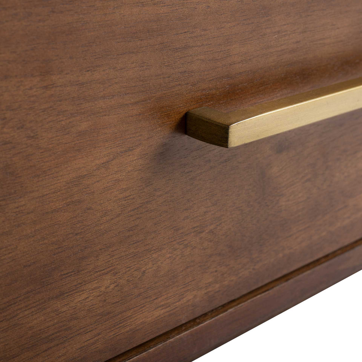 An antique brass bar pull highlights the rich brown grain of the drawer front