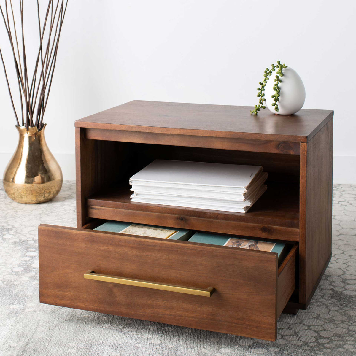 A pull-out drawer holds reading materials below an easy-access shelf of folded linens