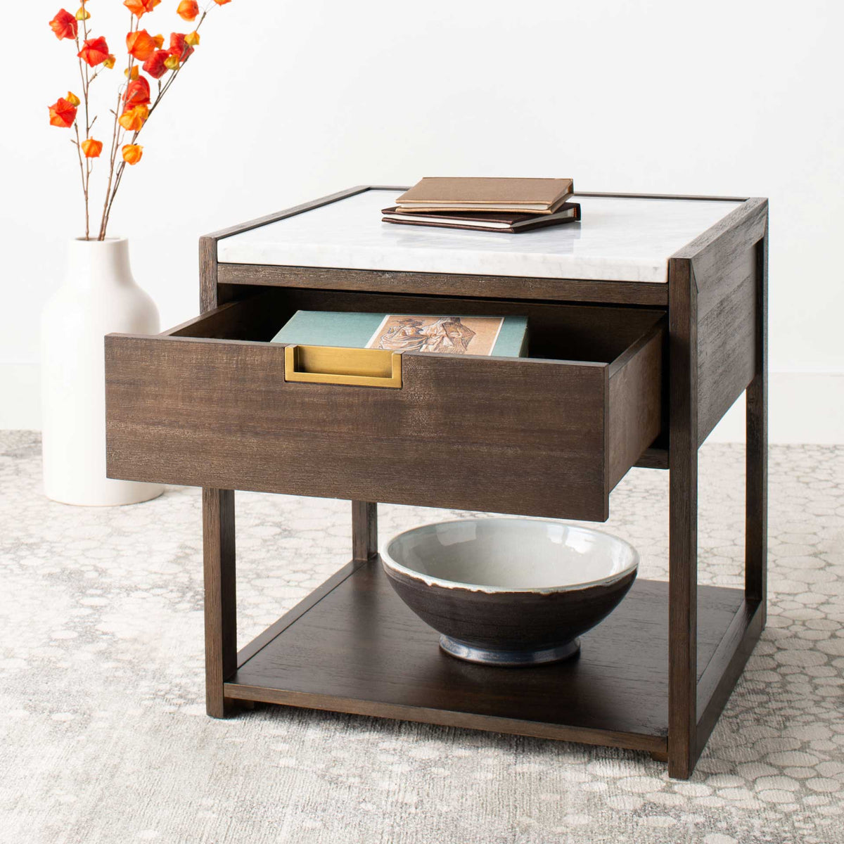 An open drawer keeps books handy above a display shelf, topped with smooth white marble