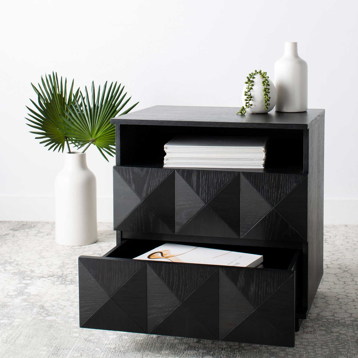 An open lower drawer reveals bedside storage beneath the nightstand's geometric front and open shelf