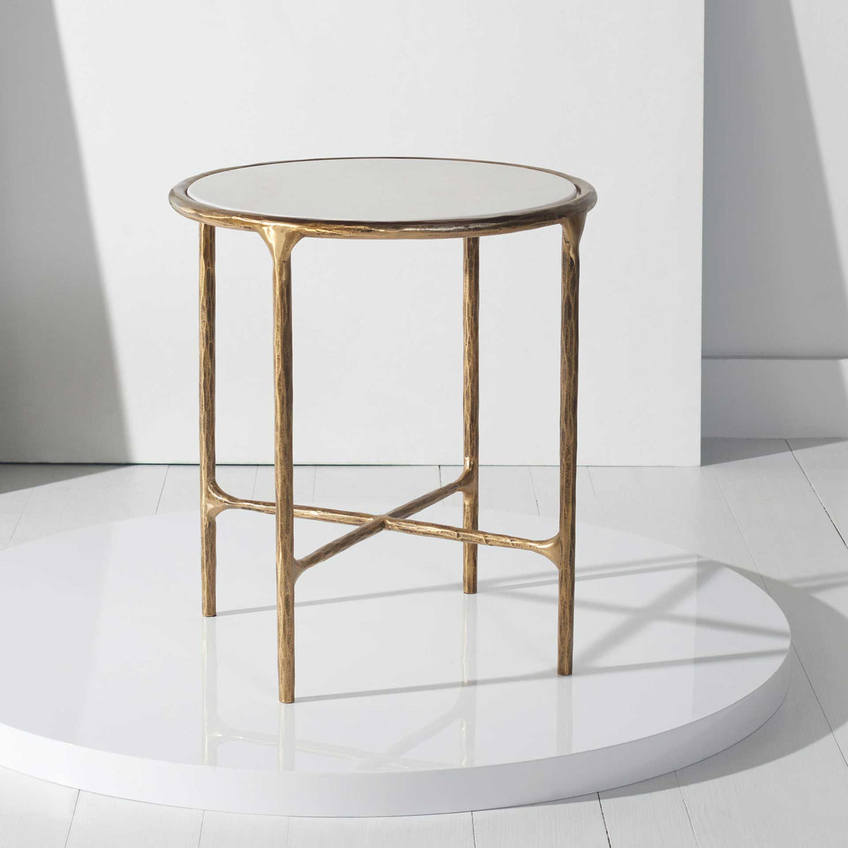 A white marble top and open brass-toned frame bring an elegant, airy accent to the living space.