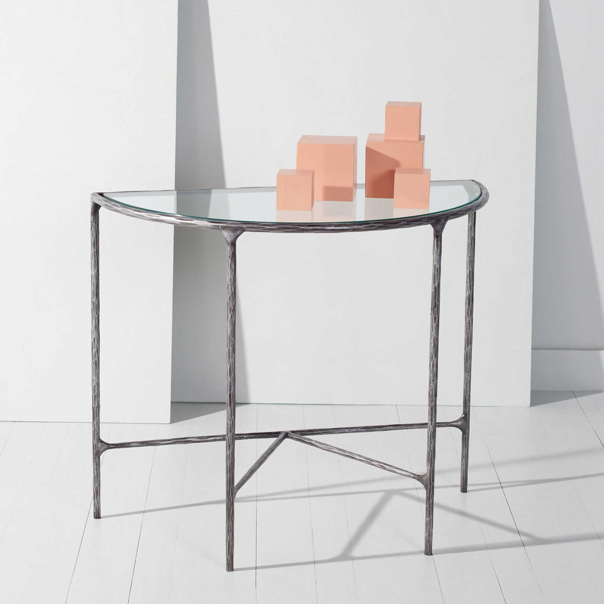 Silver-finished metal and clear glass form an airy display table with a curved profile