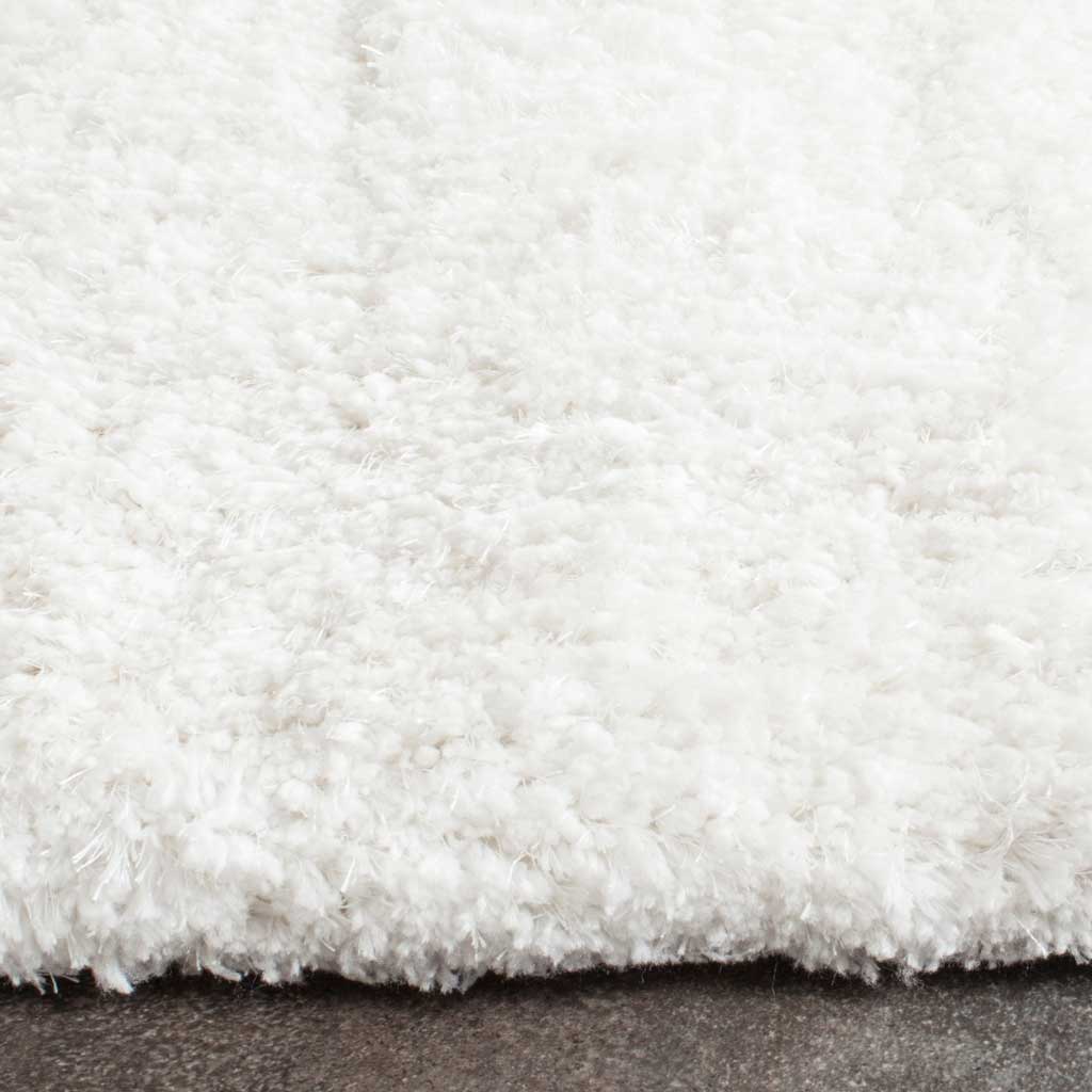 Thick white shag fibers give the rug a fluffy texture and a softly finished edge.