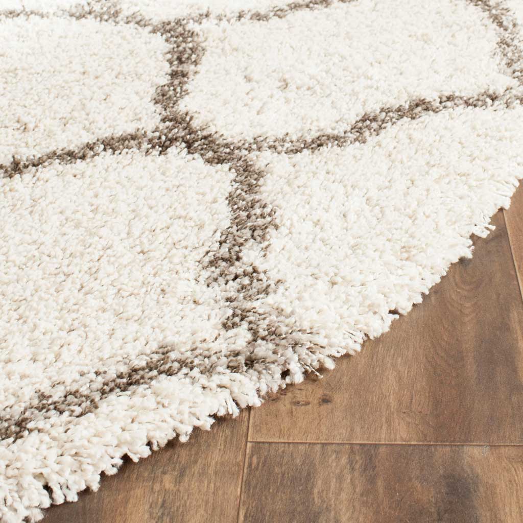 Soft ivory shag and smoky gray curves accent the rug's deep-pile edge